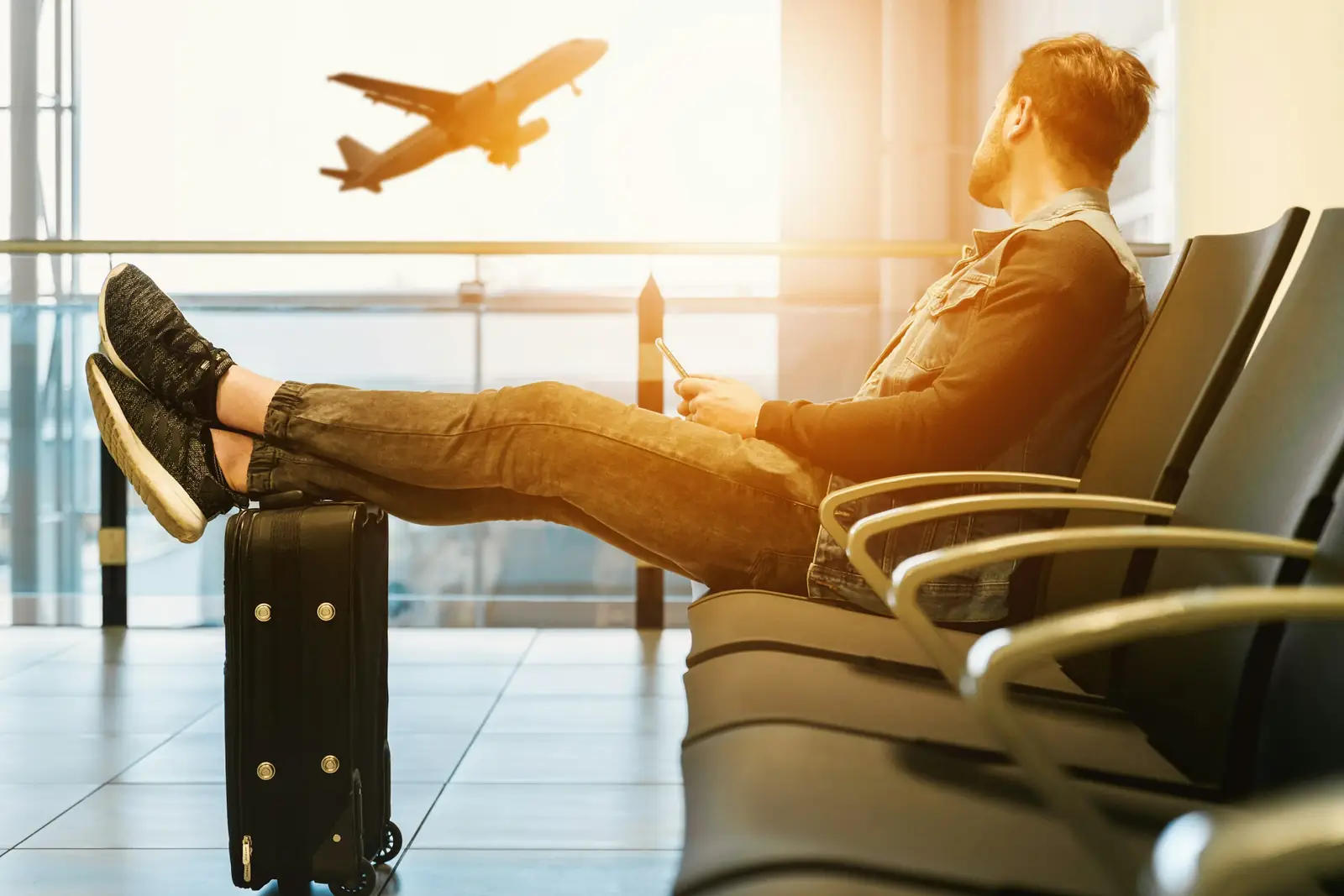 A relaxed traveller watching planes from an airport lounge