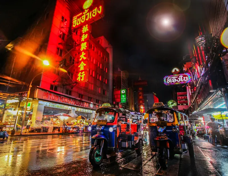 Tuk-tuks under neon signs in Bangkok's Chinatown