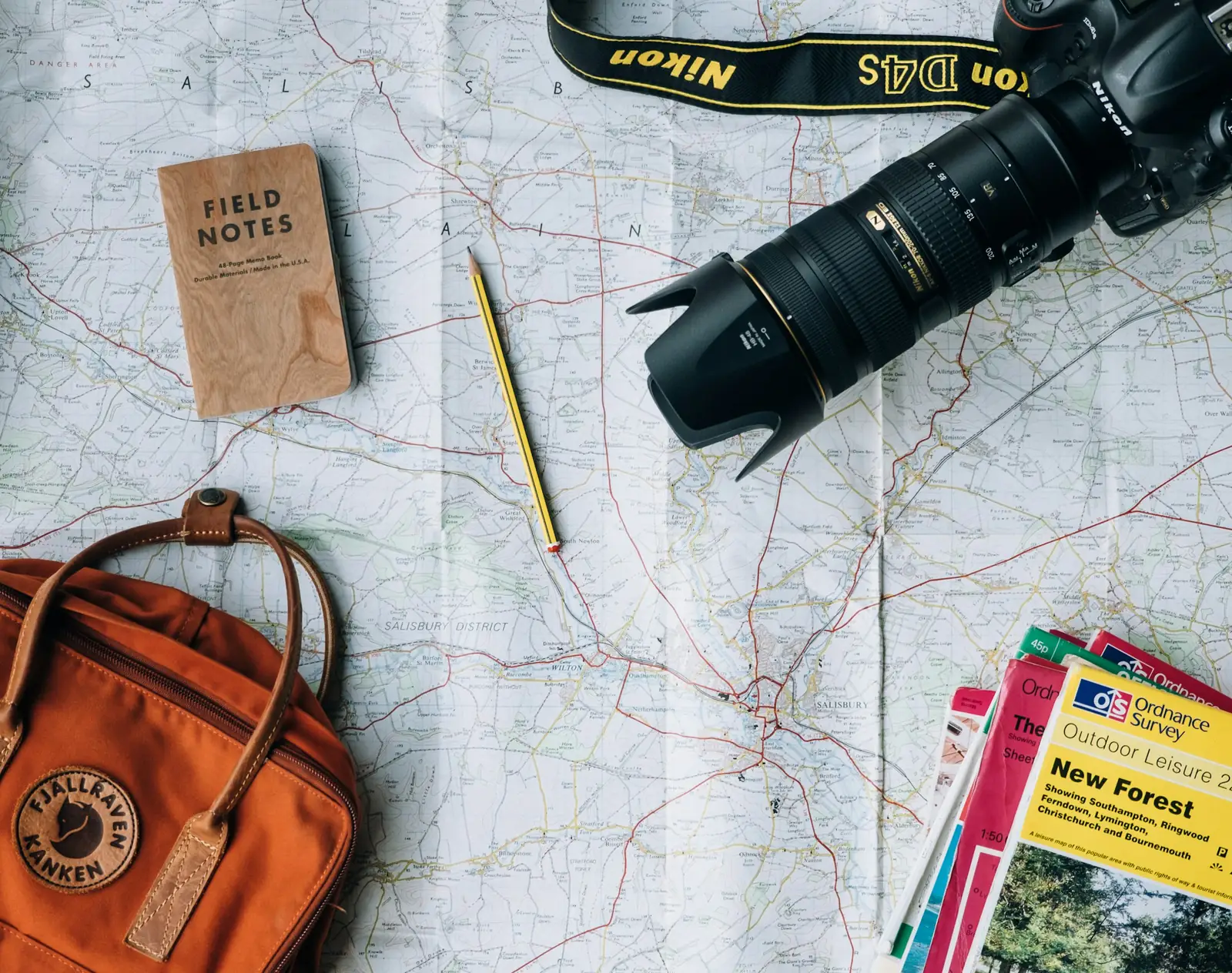 A map, camera and notebook laid out for trip planning