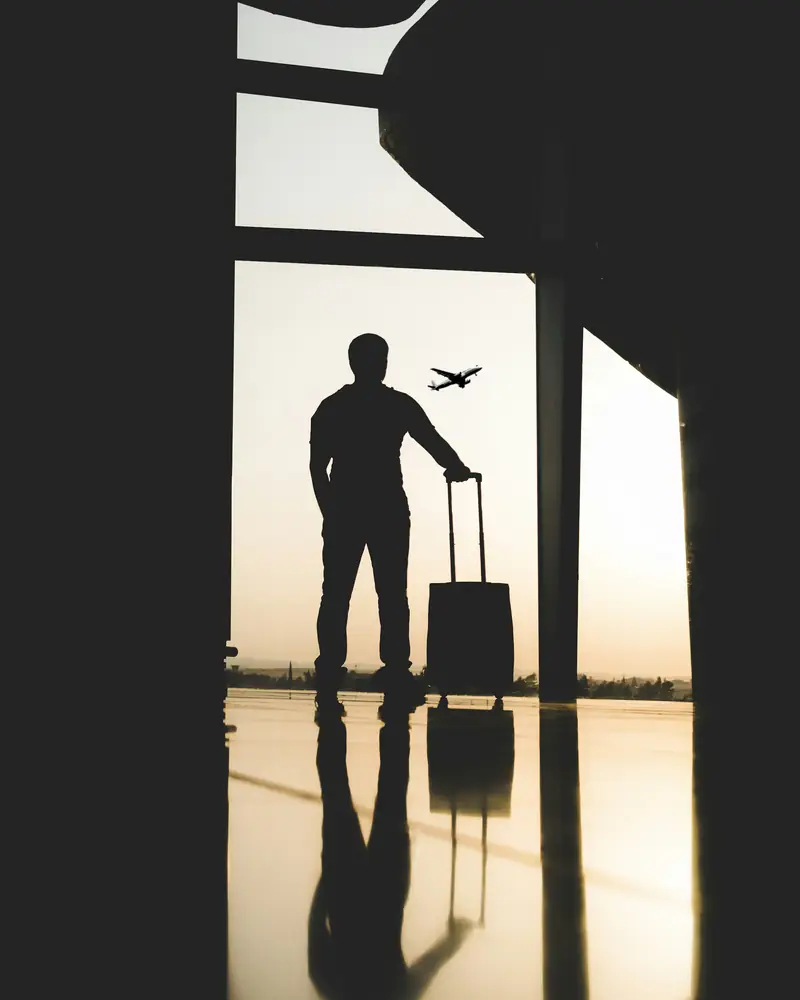 A traveller silhouetted against an airport window